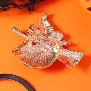 Makroaufnahme der Metallnadel und Rückseite der Brosche mit Hexe und Halloween Kürbis