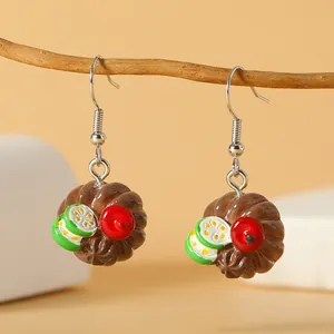 Handgemaakte chocoladetaart oorbellen met kers op een natuurlijke houten tak