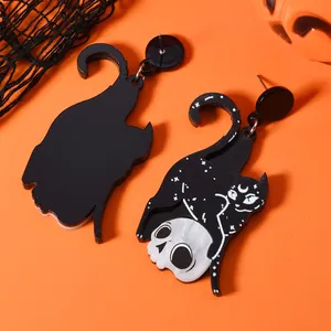 Gothic black cat embracing a white skull earrings on a vibrant Halloween orange background