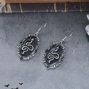 Makroansicht der Vintage Gothic Schlangenohrringe mit Silberfiligran und schwarzen Perlen