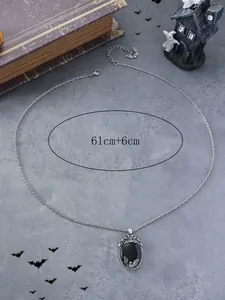 Detail view of silver Halloween necklace with black bat pendant on textured gray background