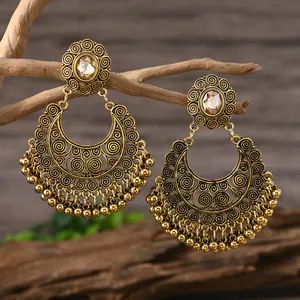 Nahaufnahme der ethnischen Boho-Ohrhänger mit antikem Goldfinish und kleinen Perlen