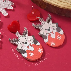 Detail of acrylic reindeer earrings with red heart studs and Christmas festive patterns