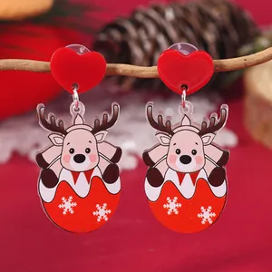 Macro shot of festive acrylic reindeer earrings on pine cones and snow background