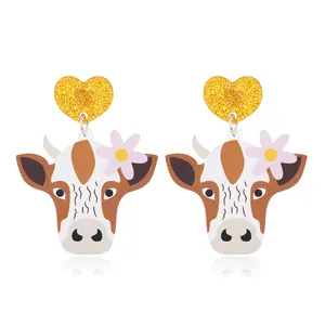 Detailed view of cute acrylic cow earrings with glittery pink hearts and floral accents