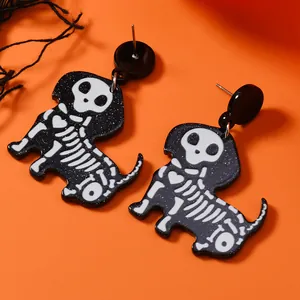 Detail of skeleton dachshund earrings in black acrylic on an orange background