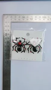 Macro detail of gothic spider earrings with red rhinestones and measurement scale
