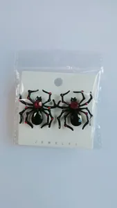 Detail of gothic spider earrings with red gemstones in retail packaging