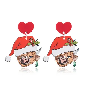 Detail of Christmas highland cow acrylic earrings with red heart studs and festive hat