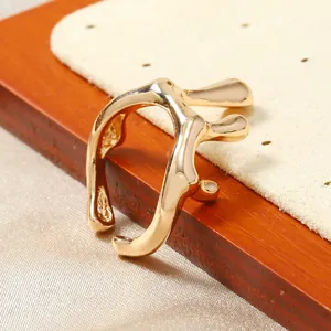 Gros plan sur la bague dorée irrégulière au design de lave et texture polie