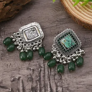 Detail of vintage bohemian silver earrings with green turquoise stones and dangling beads