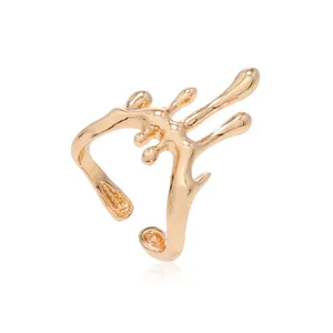 Détail macro d'un earcuff doré effet métal liquide avec un design organique fondu