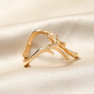 Vue macro d'une bague dorée ajourée style liquide sur fond de soie de qualité