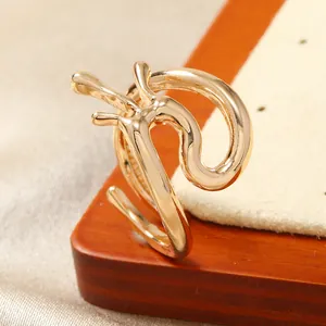 Gros plan sur une bague dorée style lave avec texture métallique fluide sur de la soie