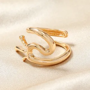 Vue détaillée de la bague dorée ondulée à double couche sur un tissu en soie élégant