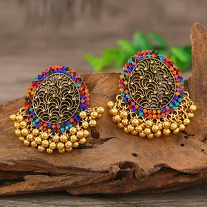 Macro detail of vintage golden Jhumka earrings with colorful rhinestones and metal beads