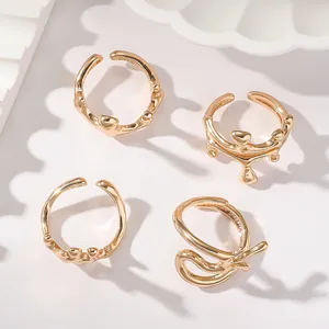 Vue macro de quatre bagues dorées minimalistes aux designs ondulés élégants et modernes