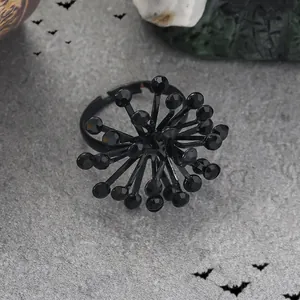 Bague Halloween gothique avec perles noires et pointes radiales sur fond pierre