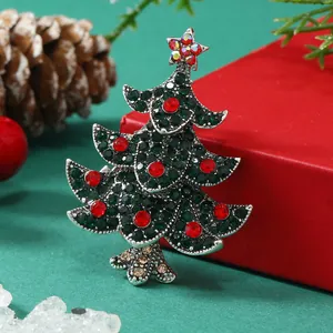 Close-up of a sparkling Christmas tree brooch with green rhinestones and a star top