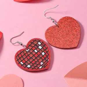 Dettaglio di orecchini a cuore glitter rossi con un design unico a mosaico