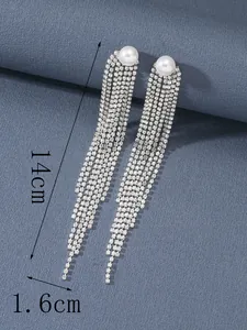 Dettaglio degli orecchini a frangia da 14cm con perle bianche e strass scintillanti