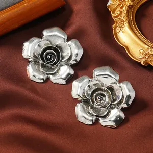 Vista dettagliata degli orecchini a rosa in argento vintage su seta marrone