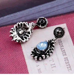 Detail view of gothic style drop earrings with blue gemstones and vintage silver finish