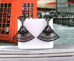 Detail of fan-shaped black drop earrings with hollow metalwork and zircon accents