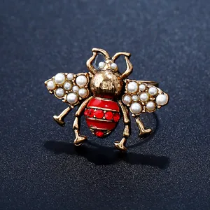 Detailed view of a vintage bee ring with gold metal wings and red enamel abdomen