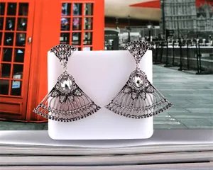 Detailed macro view of fan-shaped silver tassel earrings with zircon stones and hollow design