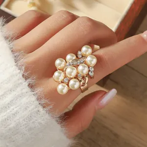 Macro shot of cluster pearl ring with gold base and zircon accents on finger