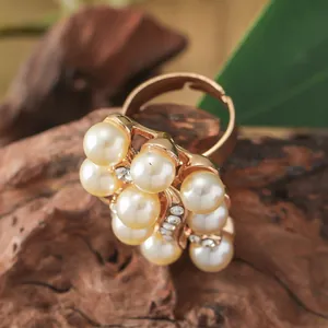 Macro shot of rose gold cocktail ring with cream pearls, zircons and adjustable band