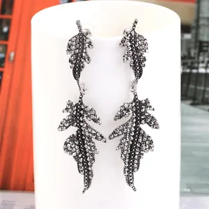 Detailed close-up of vintage leaf-shaped drop earrings with dark zircon in gunmetal silver