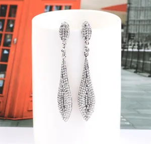 Close-up of sparkling long teardrop tassel earrings with micro-paved white crystals