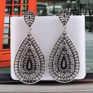 Macro view of vintage silver fan-shaped tassel earrings with black and white rhinestones