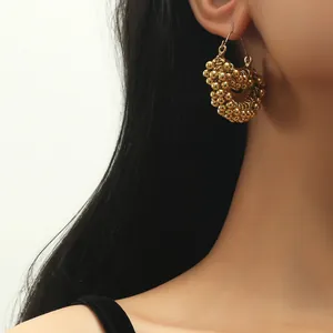 Macro shot of gold-plated hoop earrings with a textured beaded spherical design