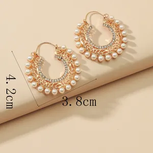Detail of 18k gold plated hoop earrings featuring white pearls and sparkling cubic zirconia