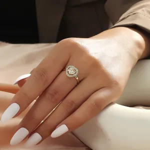 Close-up of a gold heart ring with large clear zircon stone worn on a hand