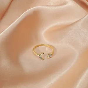 Detailed close-up of adjustable gold crescent moon and star ring with sparkling rhinestones