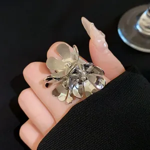 Bague double fleur argentée élégante avec pétales superposés sur l'index