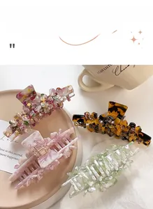 Close-up of four floral acetate hair claws with rhinestones on a decorative tray
