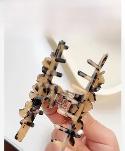 Detailed close-up of tortoise shell pattern acetate hair claw clip with spring mechanism