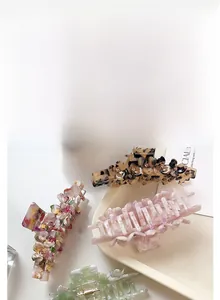 Detailed macro view of acetate hair claws with sparkling rhinestones and floral patterns