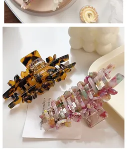 Detail of tortoise shell and floral acetate hair claws with delicate flower accents