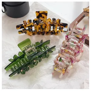 Detail of acetate hair claws with rhinestones in leopard, green, and marble patterns