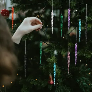 Detail of colorful acrylic icicle ornaments hanging on a festive Christmas tree