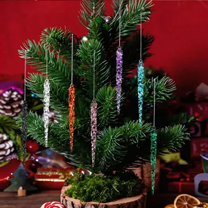 Colorful acrylic icicle ornaments hanging on a mini Christmas tree with festive decor