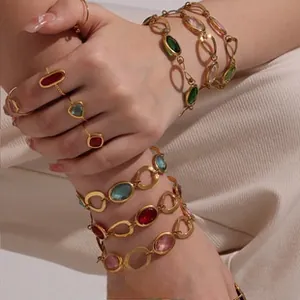 Detail of luxury gold plated jewelry set with colorful gemstones on textured fabric