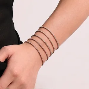 Close-up of five layered rose gold tennis bracelets with sparkling white crystals