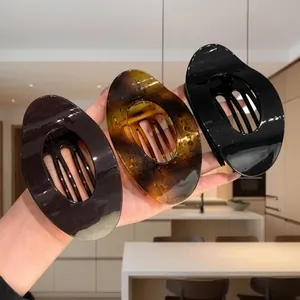Dettaglio di grandi mollette ovali per capelli in nero, caffè e tartaruga marrone